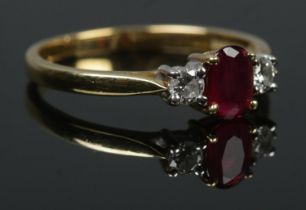 An 18ct gold diamond and ruby three stone ring. Size Q. 3.1g.