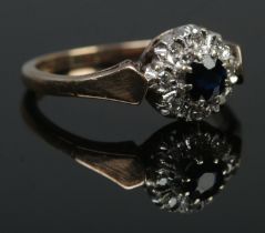 A 9ct gold diamond and sapphire halo cluster ring. Hallmarks for 1981 by B&S. Size K 1/2. 2.39g.