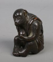 An Oriental bronze figure formed as a seated monkey. (4.5cm)