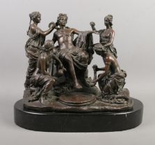 A bronze figure group formed as a Roman being attended by four maidens raised on marble base.