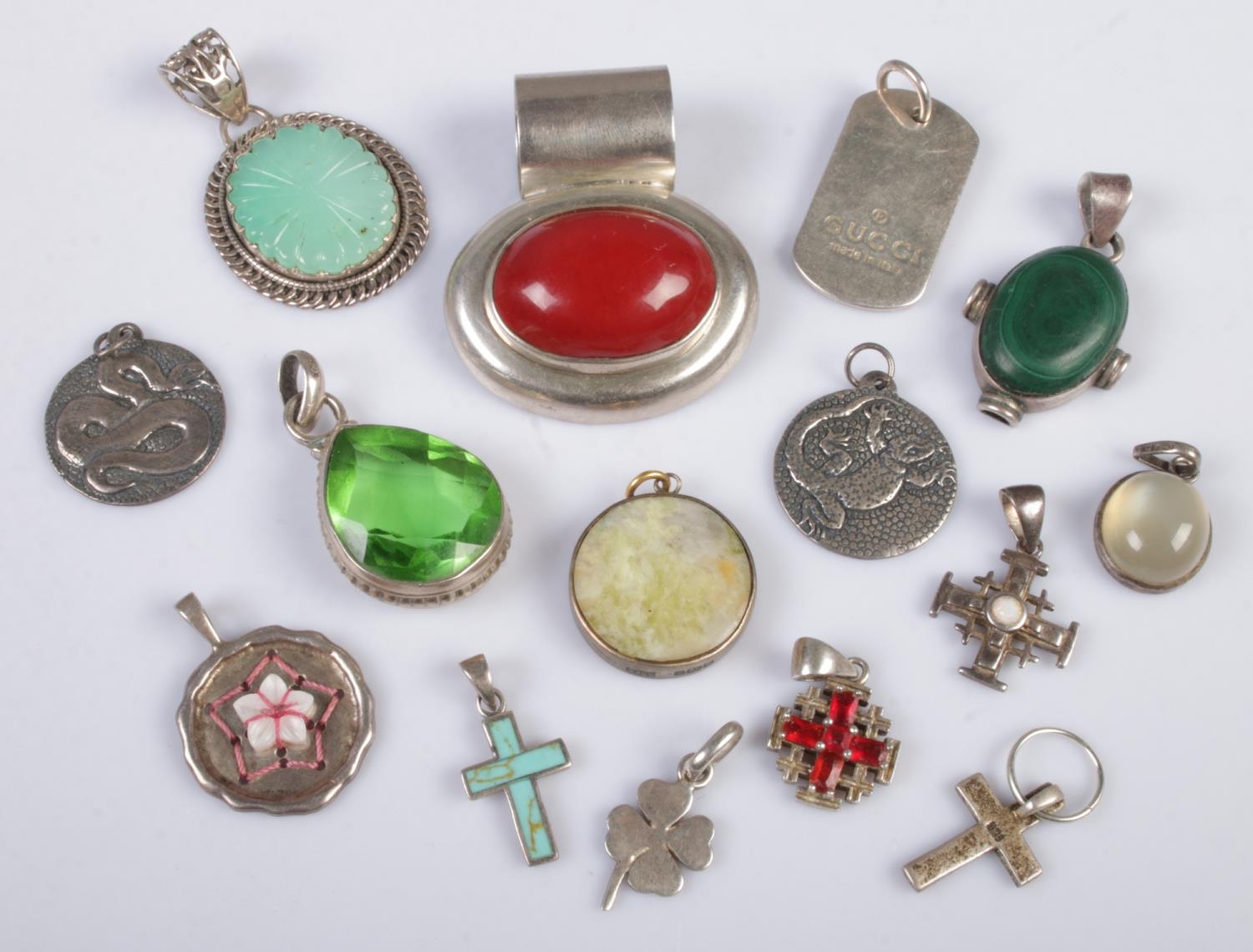 A quantity silver pendants. Includes reptile, cross, malachite example, etc. Gross weight 106g.