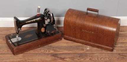 A hand crack Singer sewing machine with oak dome case. No key.