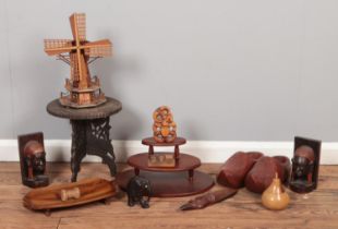 A quantity of woodenwares, to include a pair of tribal bookends, clogs, windmill model and small