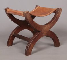 Robert 'Mouseman' Thompson, an oak xframe stool with leather seat. Having carved mouse signature.