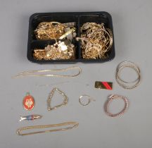 A box of gold tone costume jewellery to include necklaces, bangles, pendants, etc. Also include