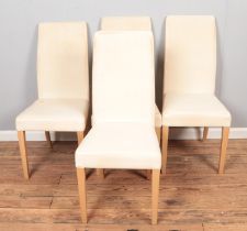 A set of four modern dining chairs.