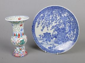 Two pieces of oriental ceramics to include vase depicting dragons and blue and white charger. Both