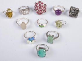 Eleven silver dress rings. Includes large pink stone cluster example, 59g.