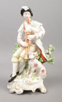 An 18th century Derby porcelain figure, modelled as bagpipe player with a dog. 18.5cm. Repair to bag