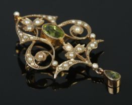 A 9ct gold peridot and seed pearl openwork brooch. Length 4.5cm. 3.95g.