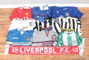 A collection of replica football shirts including Manchester United, England, Everton, Millwall,