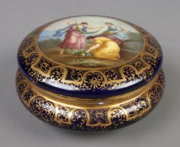 A porcelain circular powder bowl with cover, hand painted with classical maidens, within a blue