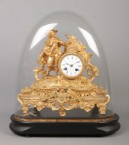 A 19th century French gilt mantel clock under glass dome. The clock surmounted with a cavalier.