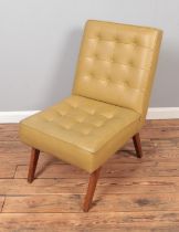 A vintage Scandinavian style beige leatherette chair with teak legs.