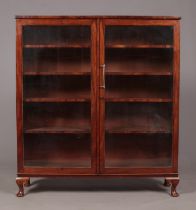 An Edwardian mahogany glazed bookcase raised on four cabriole supports. Height 136cm, Width 124cm,