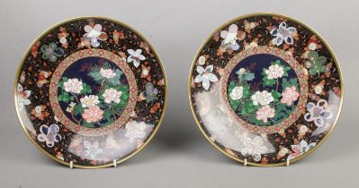 A pair of Japanese cloisonne chargers with panels decorated with flowers, landscapes and sea shells.
