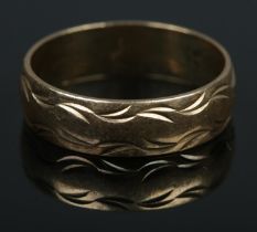 A 9ct gold wedding band featuring engraved detail. Size R, 3.5g.