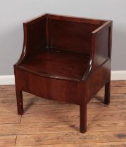 A Georgian mahogany single settle/hall chair featuring storage compartment within seat.