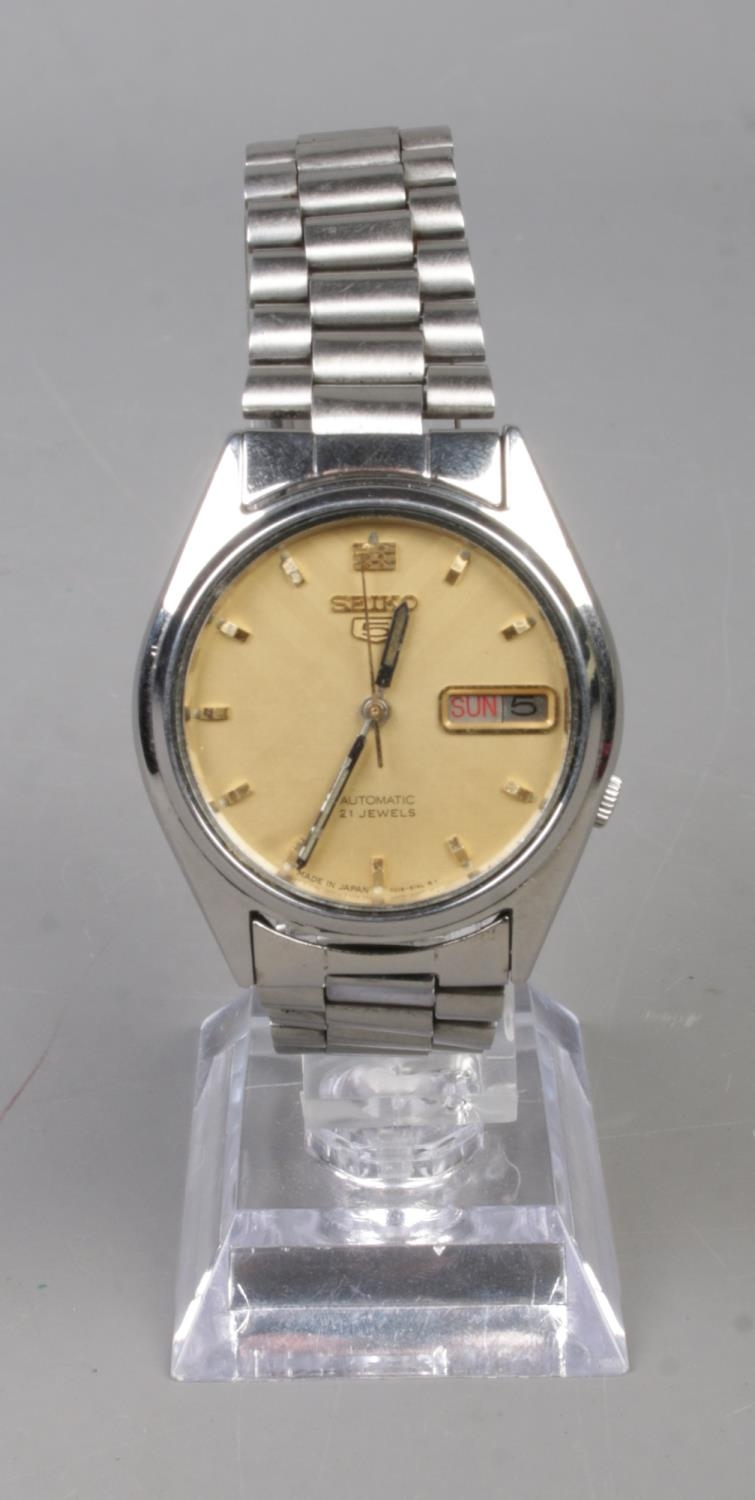 A men's Seiko 5 Automatic wristwatch featuring gold coloured face and day date display. In working