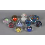 A collection of ten glass paperweights of varying sizes all featuring various animal inclusions.