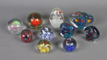 A collection of ten glass paperweights of varying sizes all featuring various animal inclusions.
