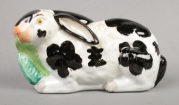 A 19th century Staffordshire left facing black and white lop eared rabbit. Length 24cm. Some