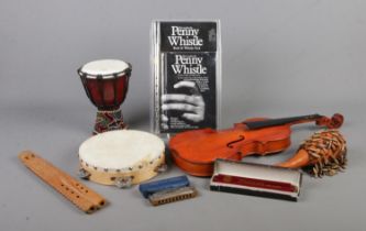 A collection of assorted musical instruments, to include small bongo, tambourine, penny whistle