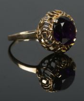 A 9ct gold ring set with a large amethyst coloured stone. Size P 1/2. 4.42g. Band slightly