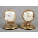 A pair of Kundo brass finish anniversary clocks in glass domes.