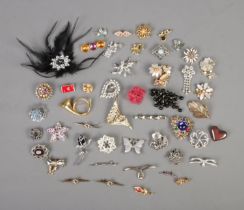 A good collection of assorted costume jewellery brooches to include Masj, feathered, musical