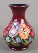 A Moorcroft pottery vase decorated in the Pansy pattern by Rachel Bishop. Height 16cm. Second