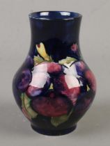 A Moorcroft pottery vase decorated in the Pansies pattern by Walter Moorcroft. Circa 1955. Impressed