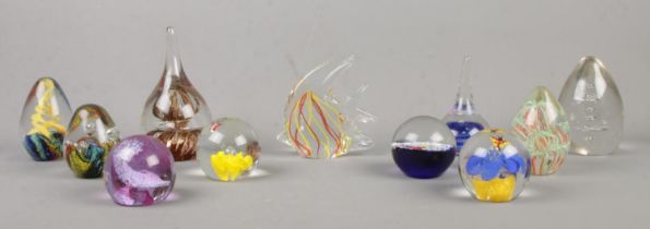 Eleven glass paperweights, to include fish shaped, starfish, spiral and strand examples.