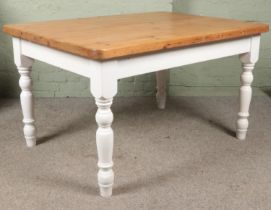 A pine kitchen table with white painted turned supports.