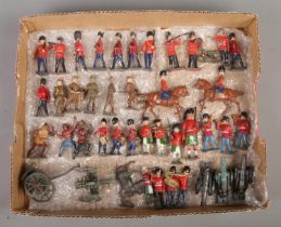 A tray of vintage painted lead military figures, including cannons, soldiers on horseback and