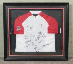 A framed England Rugby training shirt (possibly 7s) bearing players signatures. Includes Henry Paul,