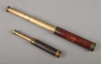 A leather and brass telescope together with another wood and brass example