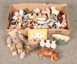 A box of pig ornaments. Includes cast iron door stop, brass example, novelty, glass etc.