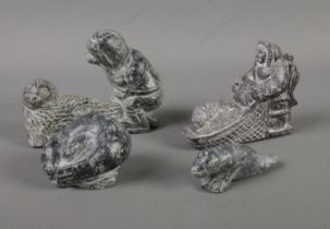 A collection of Inuit carved soapstone figures formed as seal hunters. One example featuring maker's