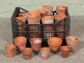 A crate of assorted terracotta plant pots, of various sizes.