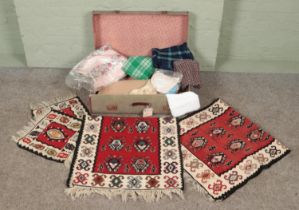 A vintage suitcase with contents of materials. Includes wool rugs, tartan etc.