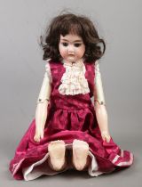 An Armand Marseille Bisque Head doll, with leather body. Marked AM4 DFD 3200 to the back. Height: