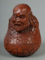 A hand carved hardwood netsuke of a Damo Monk