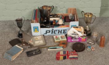 A box of collectables. Includes religious triptych, postcards, trophies, coins, etc.