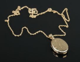 A 9ct gold engraved locket on 9ct gold chain. Locket gross weight 5.58g. Chain 2.48g.