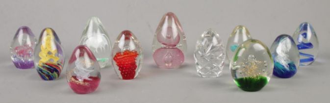 Eleven glass paperweights, including cut glass, spiral and floral examples.
