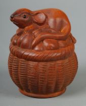 A hand carved hardwood netsuke of a mouse on basket, signed to base.