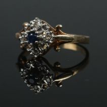 A 9ct gold ring set with a central sapphire and diamond openwork surround. Size J. 1.72g.