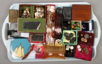 A tray of collectables. Includes lighters, compacts, hair slides, pairs of studs, etc.