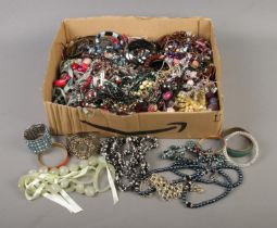 A box of assorted costume jewellery to include bangles, beaded necklaces, earrings, etc.